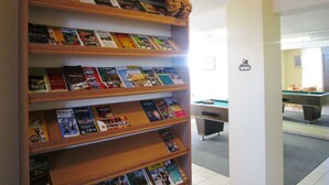 A library with wooden shelves filled with books and a small collection of teddy bears on the top shelf. - Spacious Baugnez Cottage (Malmedy-Baugnez)