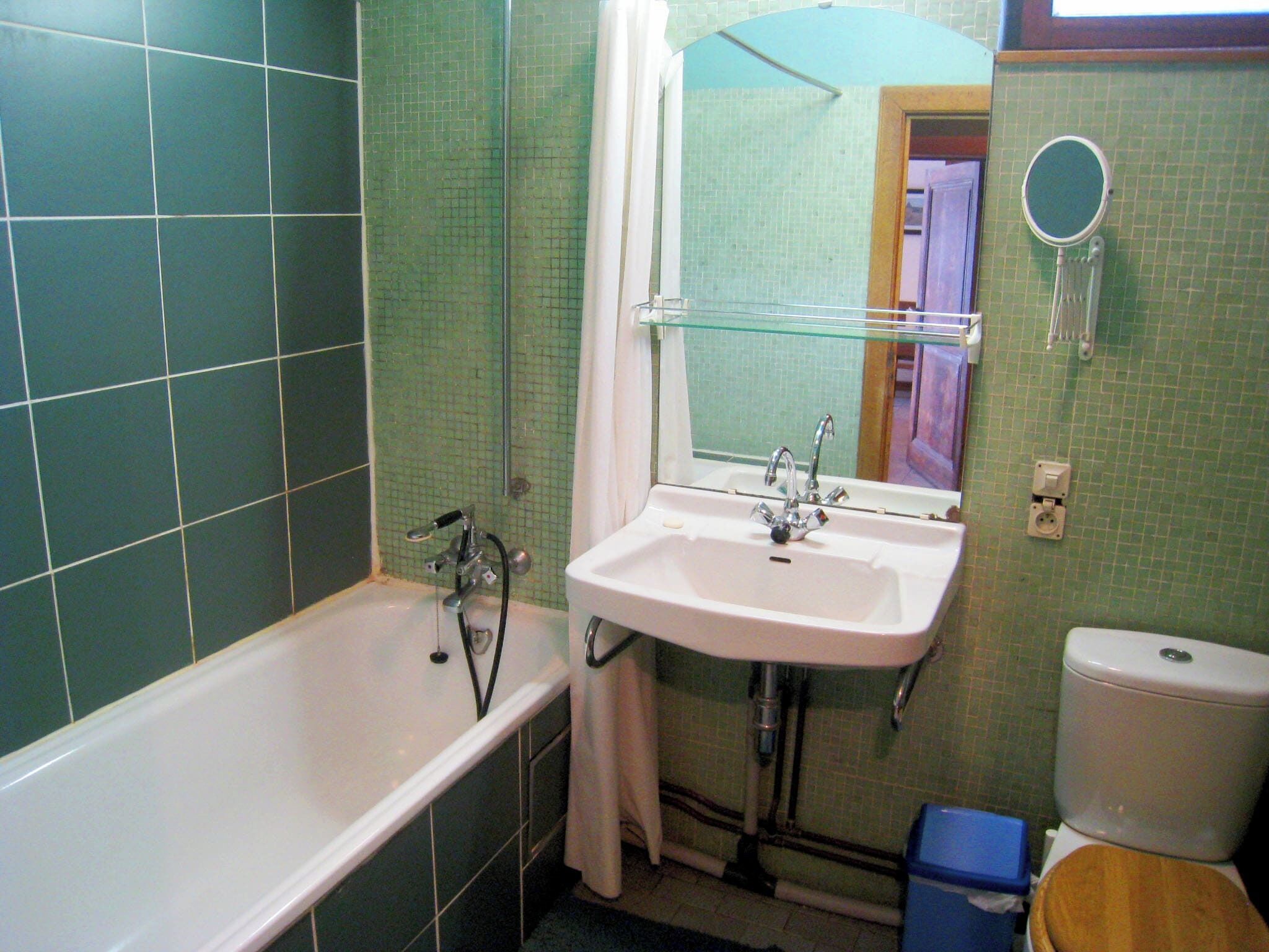 Une salle de bain équipée d’une baignoire, d’un lavabo, d’un miroir et de toilettes.