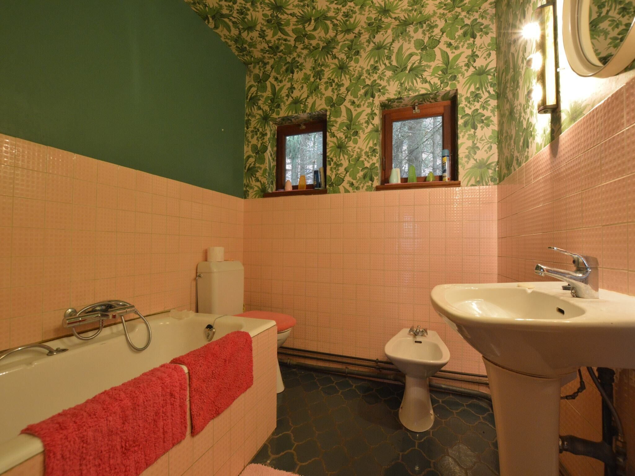 Een badkamer met een bad, toilet en een bidet.