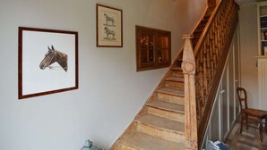 A staircase with wooden steps and a wooden handrail, leading to a landing with framed pictures on the wall. - Cosy Cottage in Barvaux-Condroz with Garden (Barvaux Condroz)