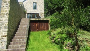 A stone building with a small balcony and a wooden fence.