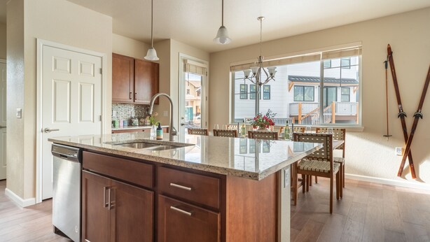 Una cocina moderna con una isla grande, armarios de madera y lavavajillas.