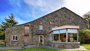 A stone building with a large glass window and a wooden door.
