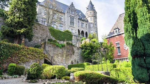 A historic building with a tower, stone walls, and well-maintained gardens. - Cozy Forest Cottage in Awenne (Awenne)