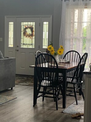 Enjoy meals in this cozy dining area with a wooden table and comfortable seating for four.
