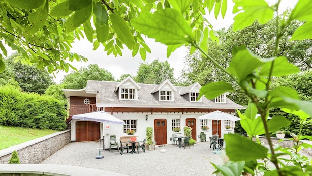A traditional house with a gravel patio, wooden doors, and a stone wall. - Cozy Escape in Bohon (Bohon-Durbuy)