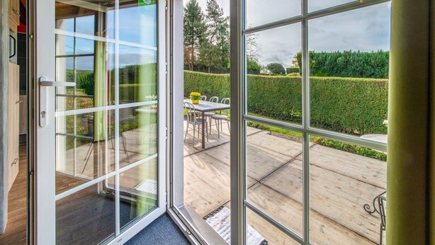 Een modern interieur met een schuifdeur die uitkomt op een terras.