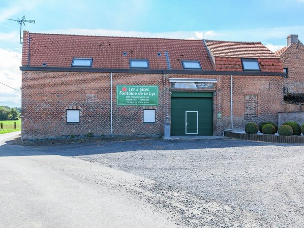 A brick building with a green door and a sign indicating 'Les 3 Gites Fontaine de la Lys'. - Cozy Home for 4 guests (Le Bizet)