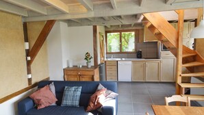 A modern kitchen with wooden cabinets, a built-in dishwasher, and a window overlooking greenery. - Comfortable Home with Sauna (Vloesberg (flobecq))