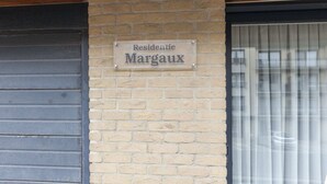 A sign on a brick wall that reads "Residentie Margaux."