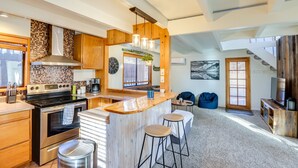 Una cocina moderna con una isla grande, electrodomésticos de acero inoxidable y armarios de madera.