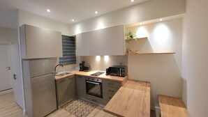 A compact kitchen with a built-in oven, a microwave, and a coffee maker. - Lorenzo Mavili Suite (Corfu)