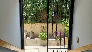 A gated entrance with a concrete pathway leading to a garden area. - CASA COCO OAXACA (Oaxaca)