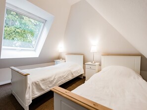 A bedroom with two single beds, a skylight, and two bedside tables with lamps. - Landurlaub in Lübberstorf (Lübberstorf)
