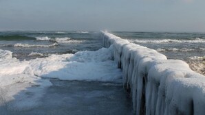 Eine eisbedeckte See mit einer massiven Eiswand im Vordergrund.