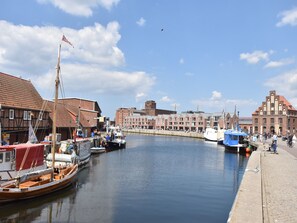 Un canal con barcos amarrados, un puente y edificios con una mezcla de estilos arquitectónicos.