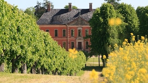 A large, red brick building with a symmetrical facade and a central entrance. - Wohnung in Klütz nahe Schloss Bothmer (Klütz)