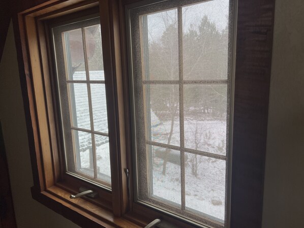 A window with a wooden frame and a metal screen.