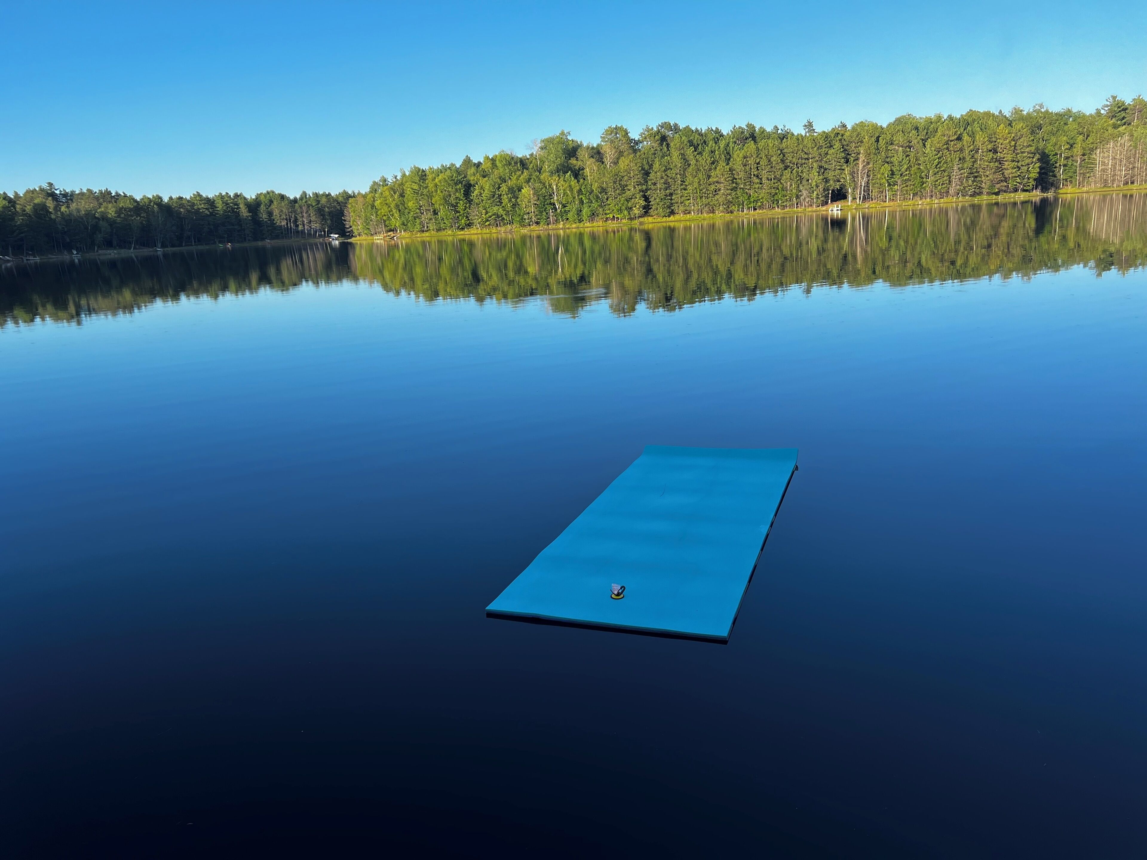 A calm lake with a floating blue platform in the center.