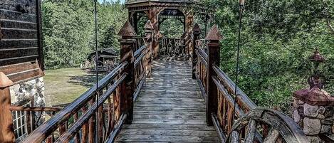 Un puente de madera que conduce a un mirador rodeado de árboles.
