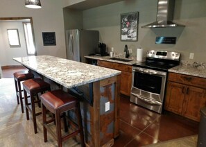 A kitchen with a granite countertop, stainless steel appliances, wooden cabinets, and a built-in oven.
