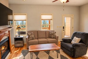 A living room with a fireplace, a sofa, a coffee table, and a television.