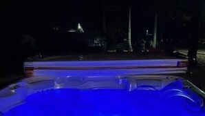 Ein Whirlpool mit digitaler Steuerung, umgeben von einer Holzterrasse.