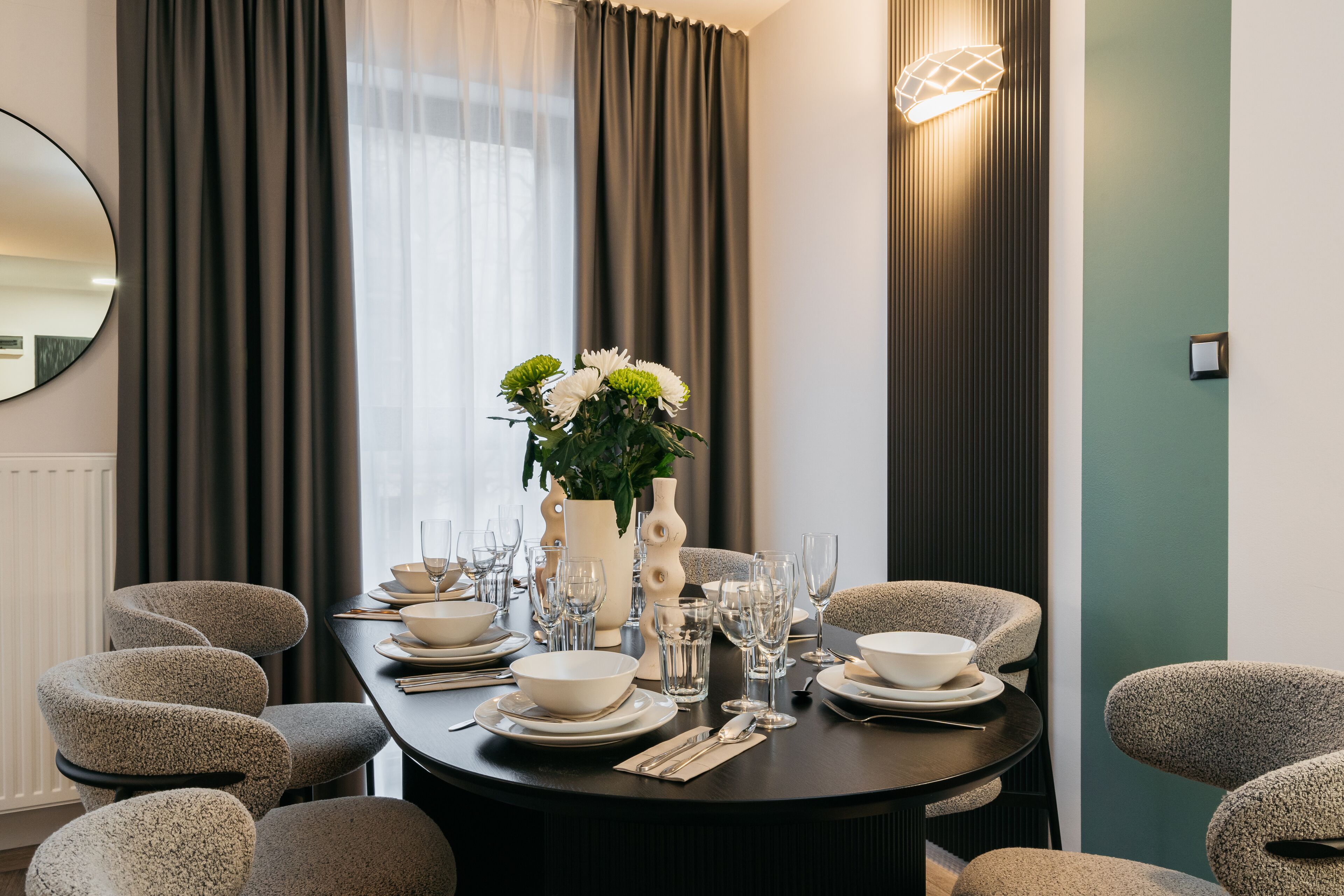 A dining area with a round table set for six, surrounded by six chairs.