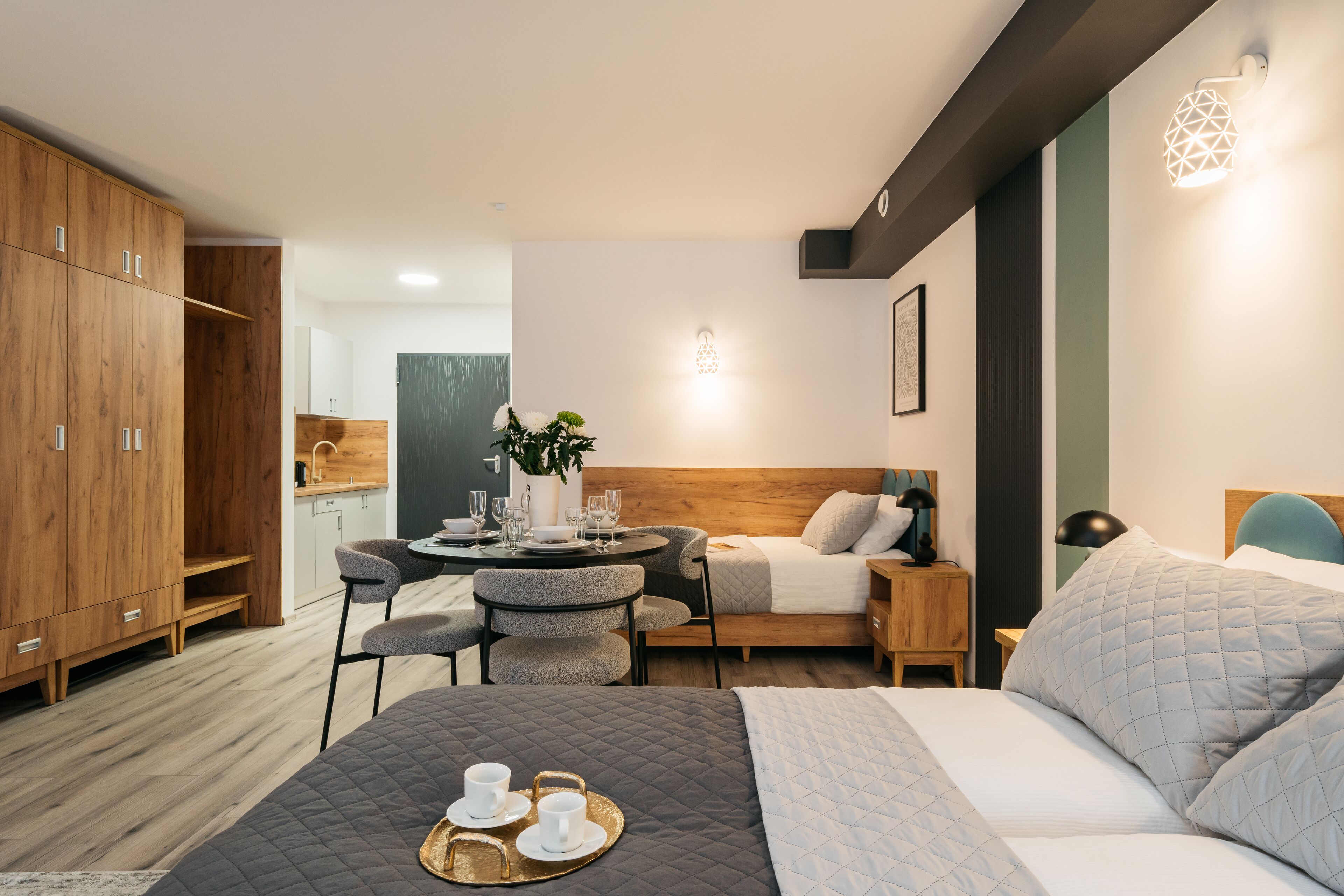 Una habitación de hotel moderna con una cama, una zona de comedor y un armario de madera.