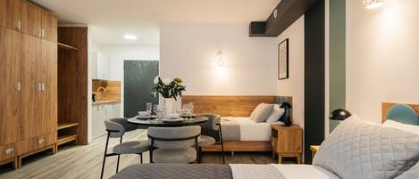 Una habitación de hotel moderna con una cama, una zona de comedor y un armario de madera.