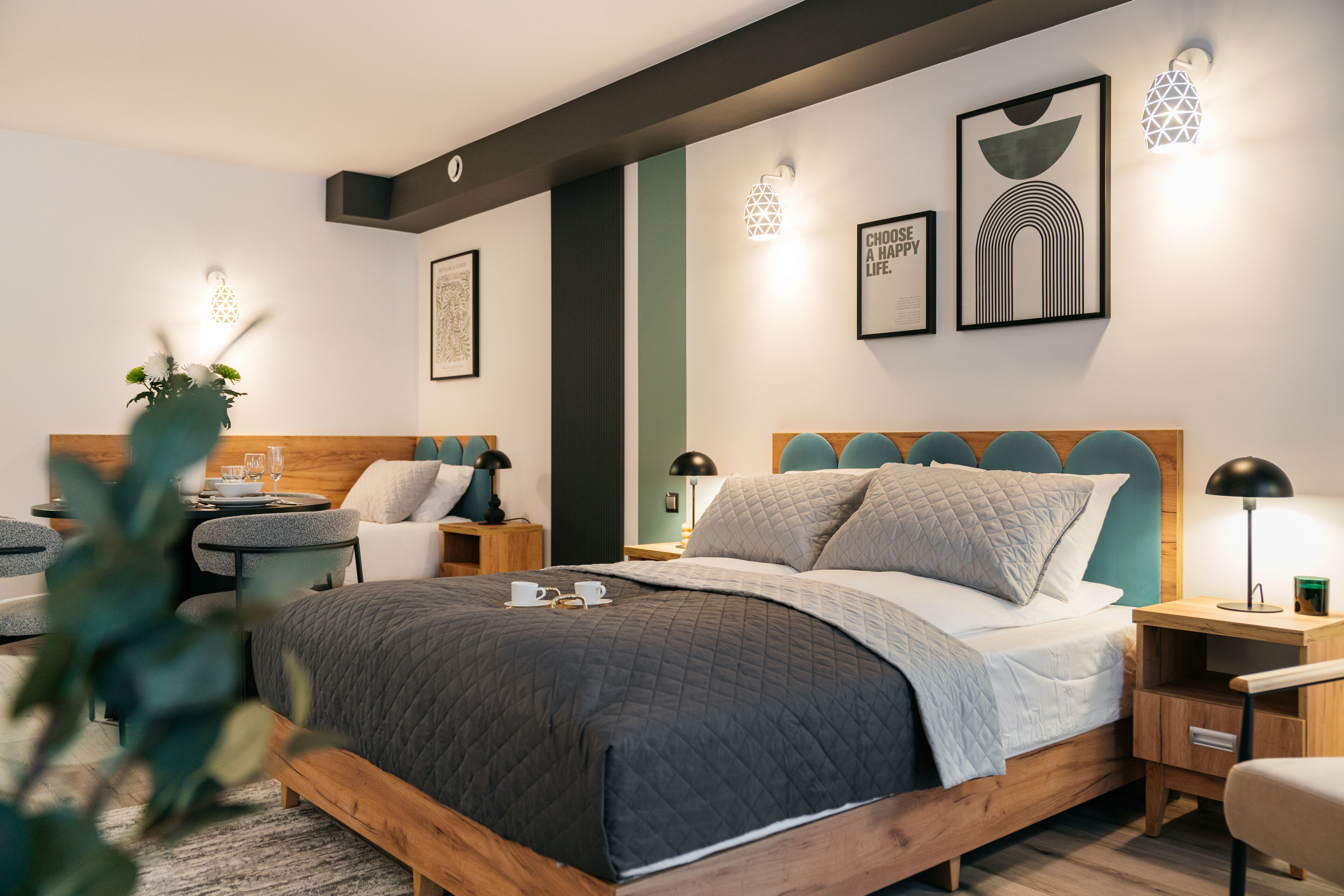 Une chambre moderne avec un lit en bois, des tables de chevet, une petite table et une chaise.