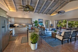 A spacious kitchen with modern appliances, a dining area with a large island, and a living room with comfortable seating and a view of the outdoors.