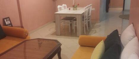 Un salon comprenant un canapé, une table basse et une table à manger avec des chaises.