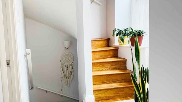 A staircase with wooden steps and a white wall.
