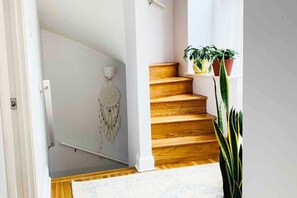 Un escalier avec des marches en bois et un mur blanc.