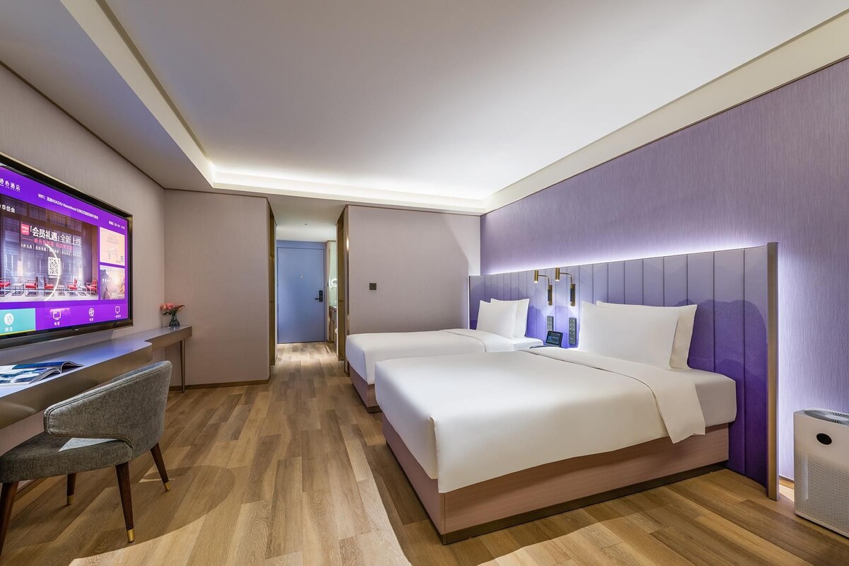 Una habitación de hotel con cama, escritorio y televisor.