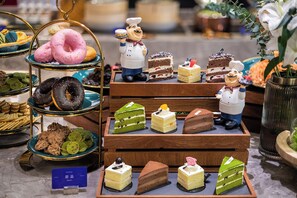A display of various desserts and pastries on tiered stands and wooden trays. - Manxin Hotel Linfen Yingbin Avenue (Linfen)
