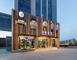 Un hotel con fachada moderna, amplios ventanales de vidrio y una entrada destacada.