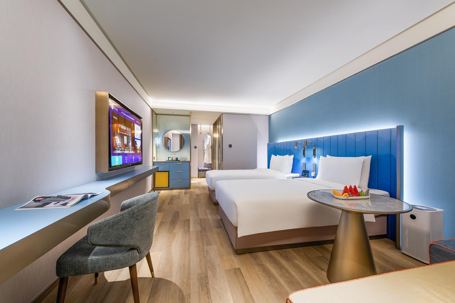 Et moderne hotelværelse med seng, sengebord og fjernsyn.