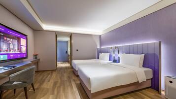 A hotel room with a bed, a desk, and a television.