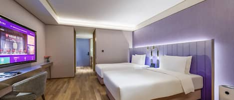 Una habitación de hotel con una cama, un escritorio y un televisor.