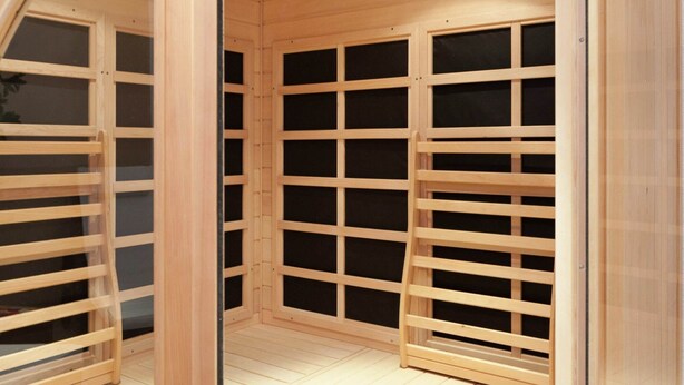Une pièce en bois dotée d’un plafond et d’un plancher à lattes, avec une colonne centrale et un mur recouvert de miroirs.