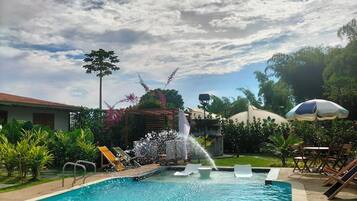 Una piscina al aire libre, tumbonas