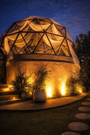A geodesic dome structure with a semi-transparent fabric covering, surrounded by potted plants and illuminated by ambient lighting. - Cannatel Exclusive Hotel (Armenia)