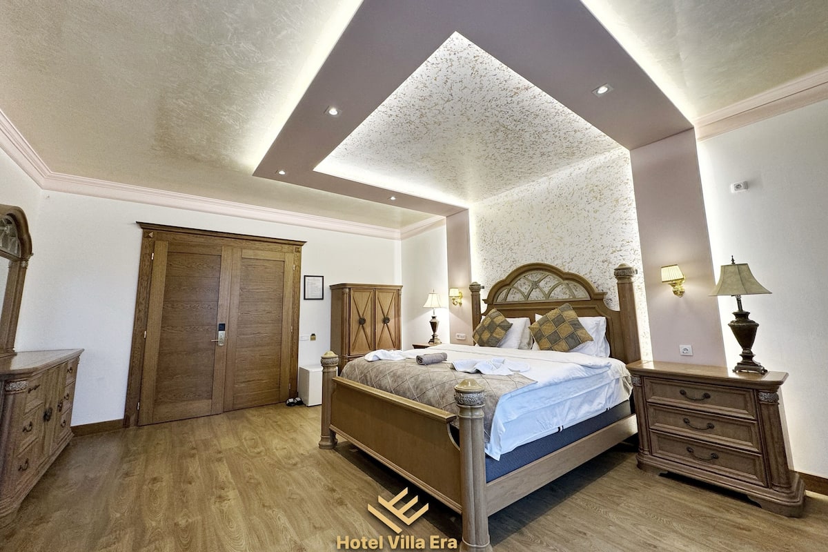 Ein Schlafzimmer mit einem hölzernen Bett, einem Kleiderschrank, einer Kommode und einer Deckenleuchte.