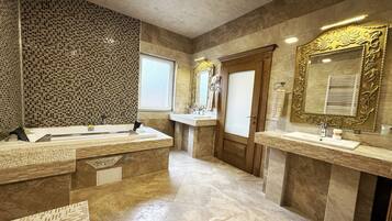 A modern bathroom with two sinks, a large mirror, and a tiled backsplash.