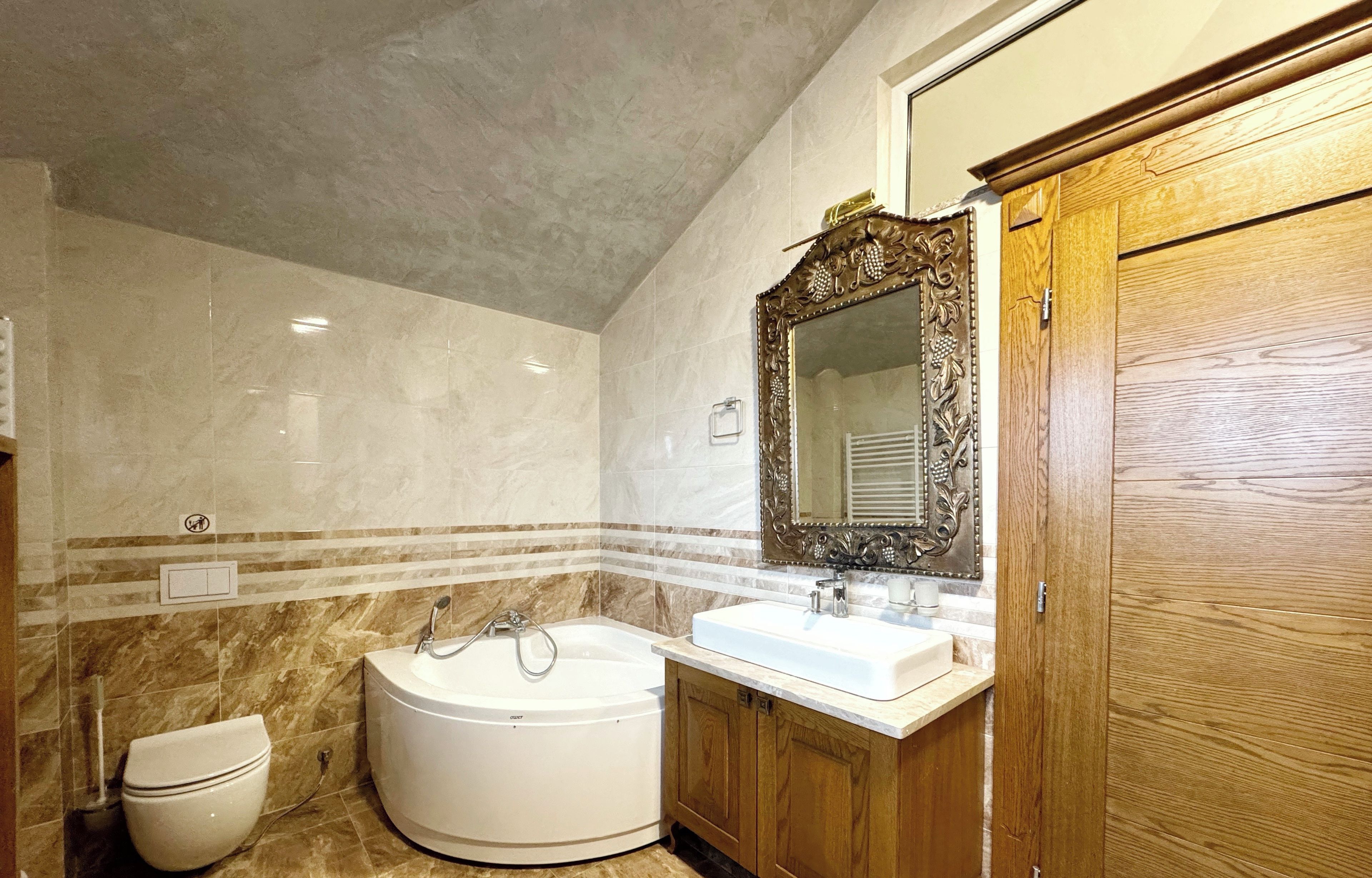 A bathroom with a bathtub, a toilet, a sink, and a wooden cabinet.
