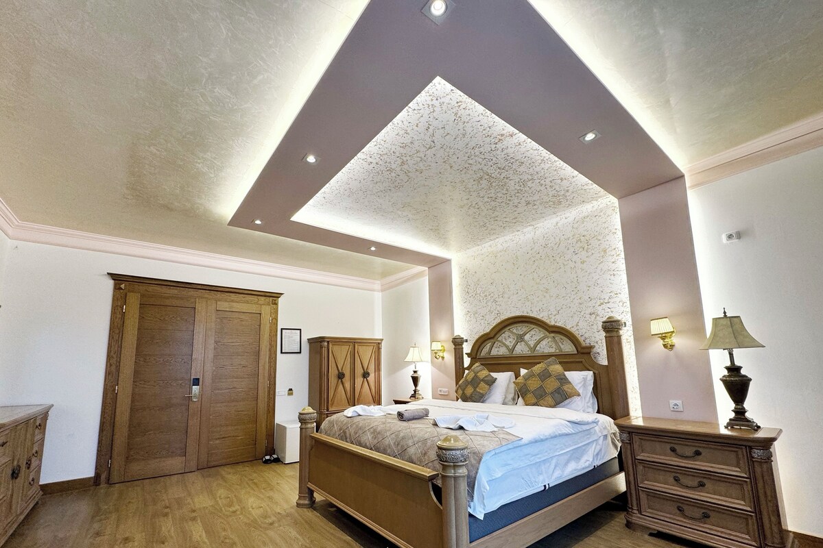 Un dormitorio con cama de madera, armario, cómoda y lámpara en el techo.