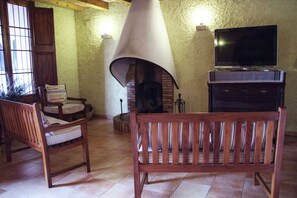 A cozy living room with a fireplace, wooden furniture, and a television. - Mansion in Maians with Private Pool (Maians-Castellfollit del Boix)