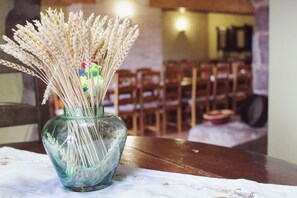 A glass vase with dried wheat stalks and a colorful chicken ornament on a table. - Mansion in Maians with Private Pool (Maians-Castellfollit del Boix)